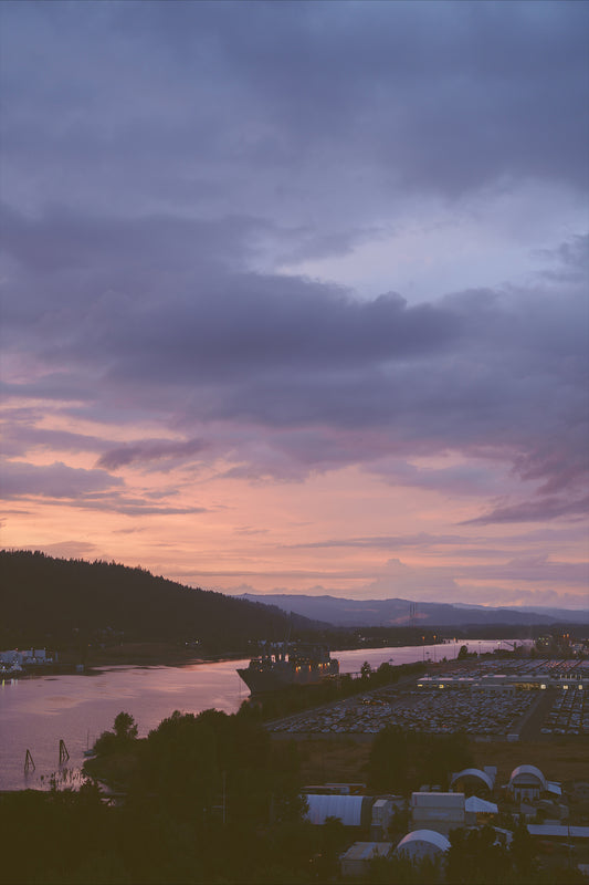 a beautiful sunset on the Willamette river in Portland with a large ship on the water