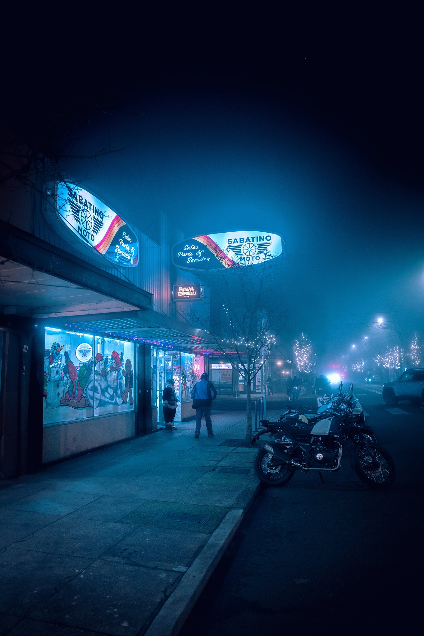 a man walking alone near a motorcycle shop on a foggy night in st johns portland oregon